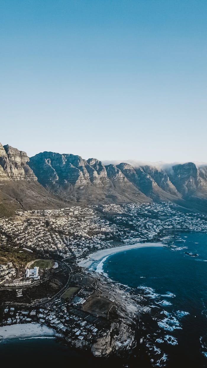 journey Stunning aerial shot of Cape Town's coastline with Table Mountain in the background during the day.
