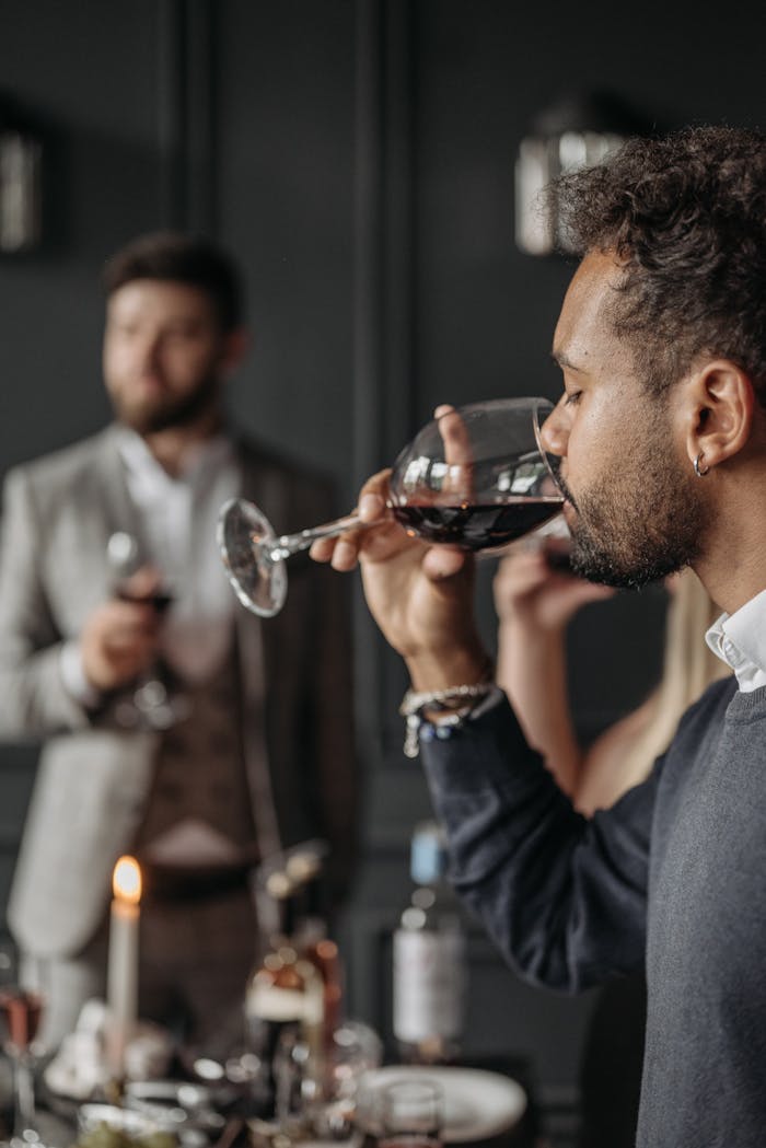 Elegant scene of people enjoying red wine at a stylish indoor gathering.